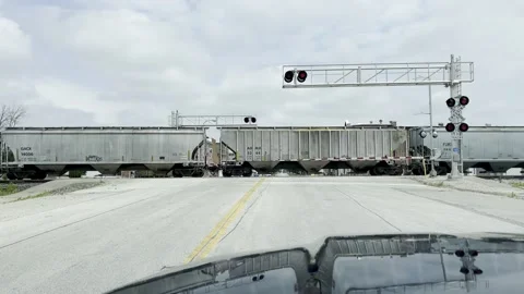 Waiting at Railroad Crossing - Train Transporting Corn Video stock 217182255