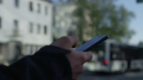 Waiting with a smartphone at the bus stop with the bus in the background Stock Footage 132708429