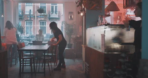 Waitress cleaning up the table then walking away Stock Footage 203582209