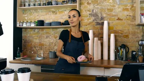 Waitress giving donuts and two cups of coffee to the customer. Stock Footage 94337545