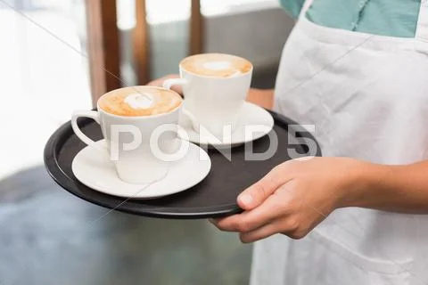 Waitress holding tray with cappuccinos Stock Photos