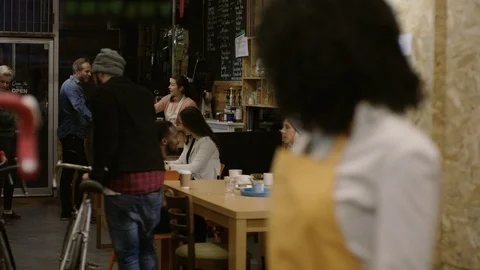 Waitress looking at customers and smiling at camera at bike garage cafe Video stock 108050308