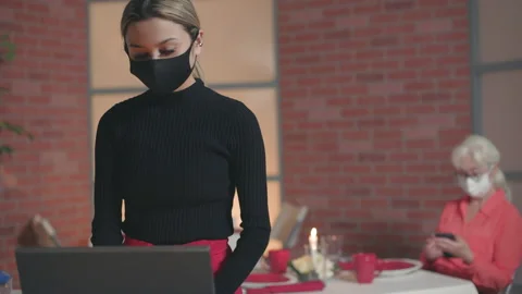 Waitress with mask enters info into the computer Stock Footage 146669736