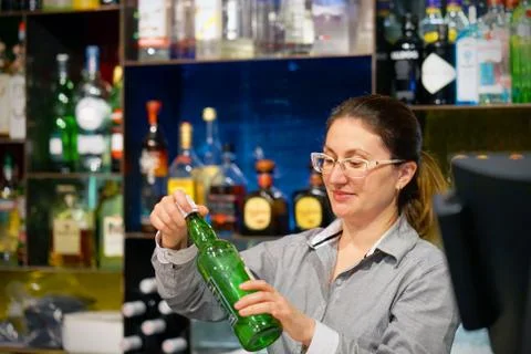 The waitress opens a bottle of whiskey Stock Photos