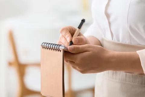 Waitress or server taking an order with a pen and blank spiral notebook, Hosp Stock-Fotos