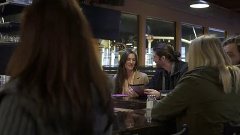 Waitress serving beer to a young couple Stock Footage 77095437