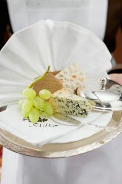 Waitress serving blue cheese with bread and grapes Stock Photos