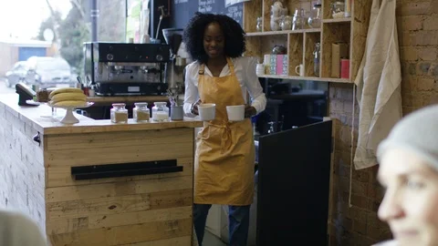 Waitress serving coffee to group of friends sitting together in cafe Video stock 108039935