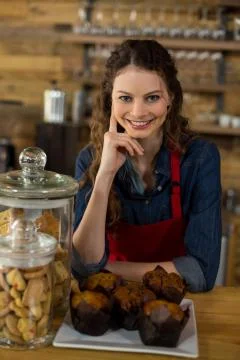 Waitress serving a cup cake at counter Stock Photos