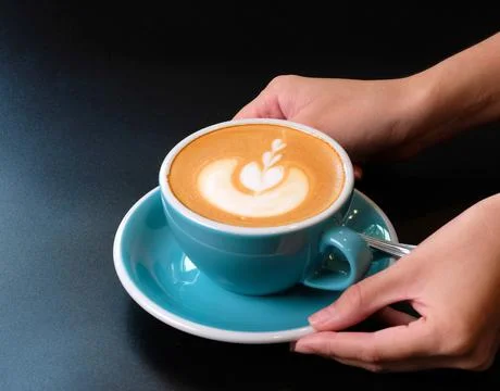 Waitress serving a cup of coffee to customer. Stock Photos