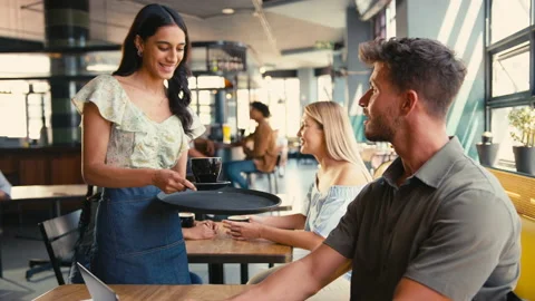 Waitress Serving Drink To Man Working On... | Stock Video | Pond5