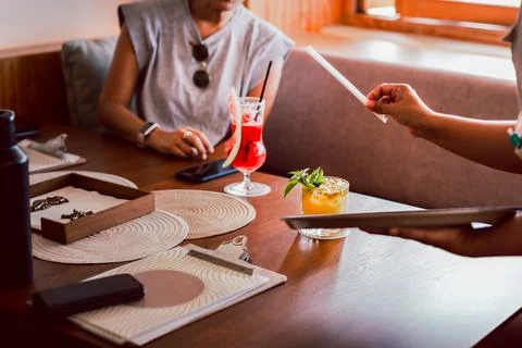 Waitress serving fresh passion fruit drink to customer in restaurant. Stock Photos