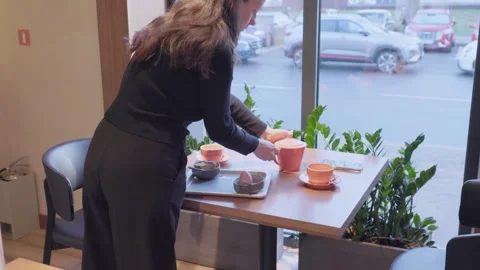 Waitress Setting Tea Table by Window Concept of Hospitality Mood Video stock 336470015