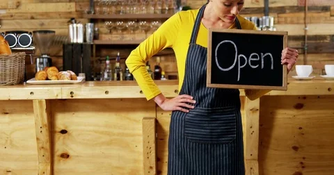 Waitress showing slate with open sign in cafe Stock Footage