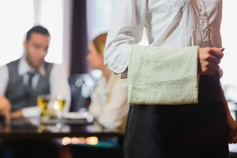 Waitress standing in front of two business people talking Stock Photos