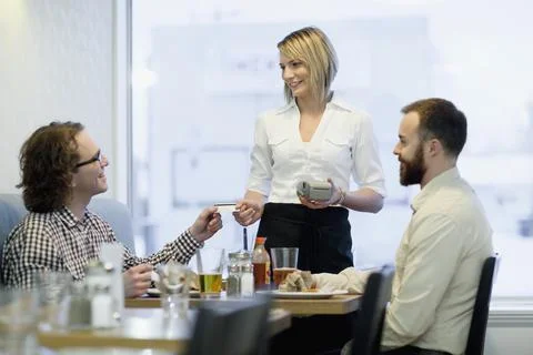 Waitress taking debit payment from customer Stock Photos