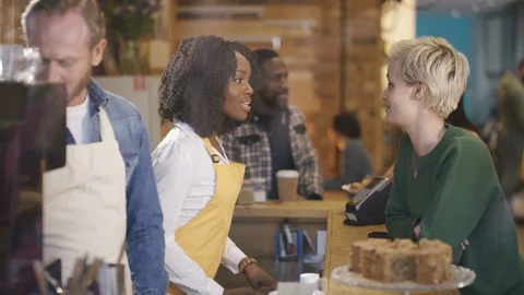 Waitress taking order and accepting payment from customer at cafe counter Stock Footage 108016937