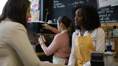Waitress taking order and accepting payment at bike garage cafe counter Stock Footage 108029701