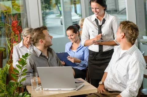 Waitress taking order from businessmen in cafe Stock Photos
