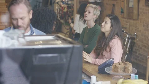 Waitress taking orders and getting payments done from customers at cafe Stock Footage 108021899
