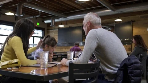 Waitress taking orders from a family Video stock 77079142