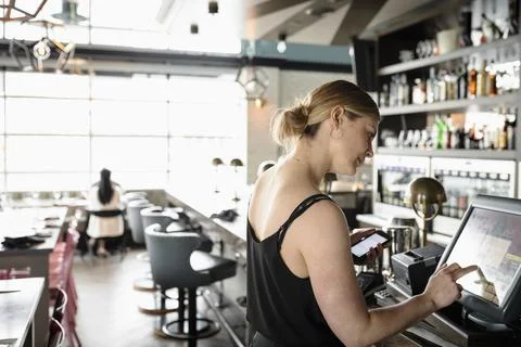 Waitress at touch screen computer in bar Stock Photos