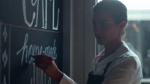 Waitress writing on blackboard menu in cafe. Stock Footage 64099253