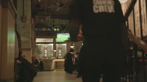 Waitstaff Serving Food in Busy Beijing Brewery with Patrons Dining and Watching Stock Footage 345761802