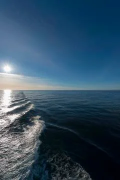 Wake of a boat facing sun Stock Photos