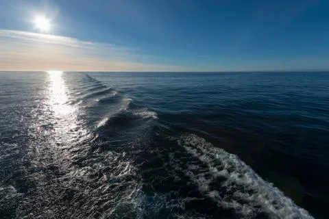 Wake of a boat facing sun Foto stock