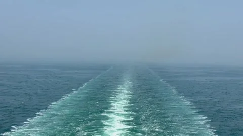 Wake of a ship moving through calm blue ocean water with misty horizon Vidéo 334353334