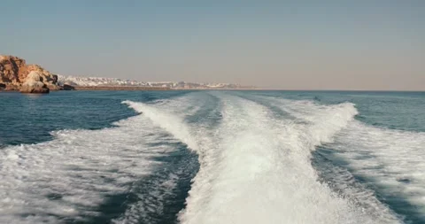 Wake water trace with white foam from waves behind tourist speed boat Stock Footage 247128525