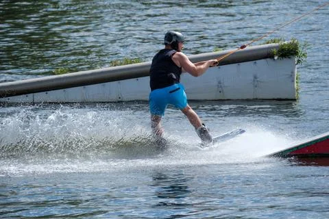 Wakeboarder approaching obstacles during cable wakeboarding training Stock Photos