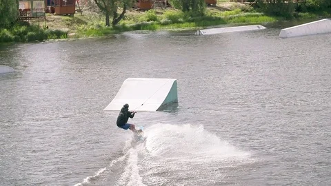 Wakeboarder crashes tricks at cable wake park HD wakeboarding slow-motion video Stock Footage 79239788