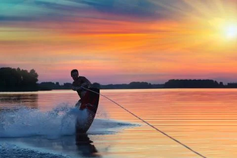 Wakeboarder does tricks on the wake. Beautiful summer background. Active holi Stock Photos