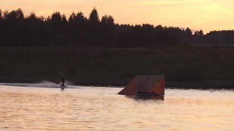 Wakeboarder doing 360 from kicker on a sunset Stock Footage 67354948