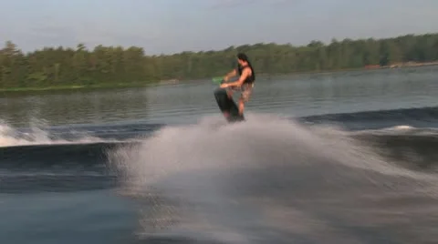 Wakeboarder doing a backside 180 away from the boat Stock Footage 21088076
