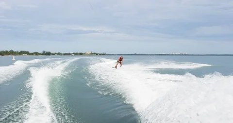 Wakeboarder doing tricks while wakeboarding in the sea during summer Stock Footage 111423486