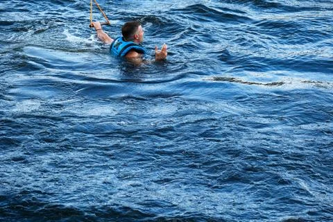 Wakeboarder floating in water after failed trick Photos