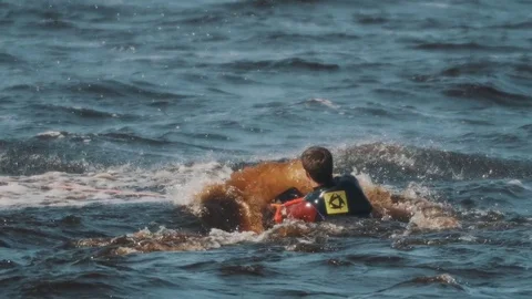 Wakeboarder in full swimsuit pulled out of water of lake with stretched string Stock Footage 75779945