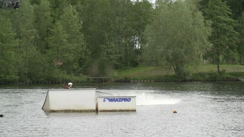Wakeboarder performing a backroll over a kicker [Slomo] Stock Footage 70133260