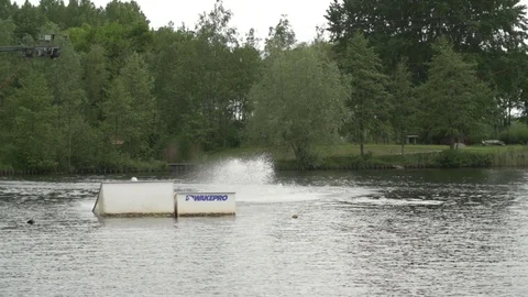 Wakeboarder performing a backroll over a kicker [Slomo] Stock Footage 70133578