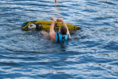 Wakeboarder preparing to restart after fall in cable park Photos