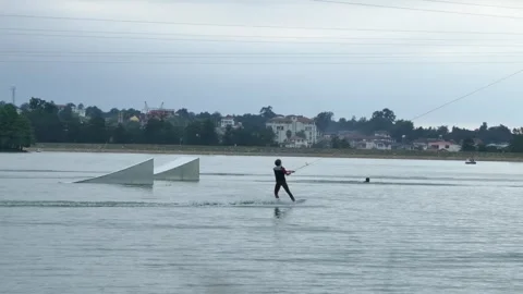 Wakeboarder ride towards ramp while one falls into water with splash Stock Footage 318680687