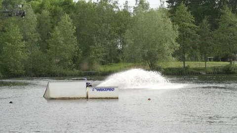 Wakeboarder tries to do a back-roll over a kicker but fails [Slomo] Stock Footage 70133565