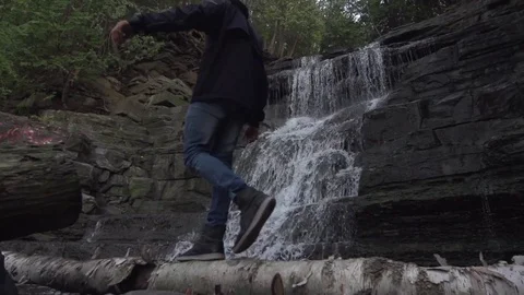 Walk Across Fallen Log with Water Fall in The Background Stock Footage 79736538