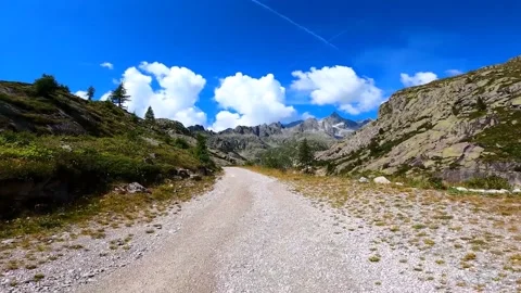 Walk along a mountain trail with a view of the remarkable mountains and clouds i Stock Footage 149321884