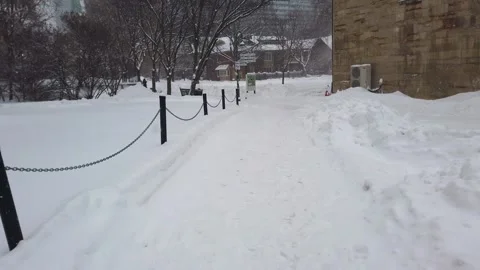 A walk along a snowy path with views of old buildings and modern skyscrapers. Video stock 302566656