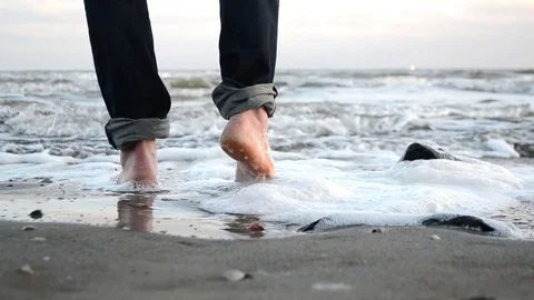 Walk barefoot along the sandy shore of the winter sea Stock Footage