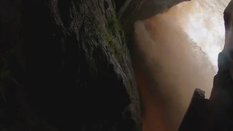 A walk behind a waterfall at sunset Stock Footage 146326509